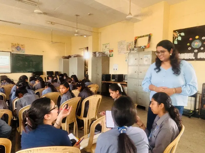 Students seated in a circle for a discussion, with their teacher standing