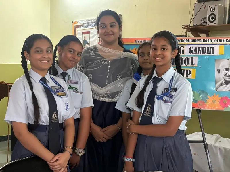 Four senior students in uniform standing with their TalkTheTalk teacher